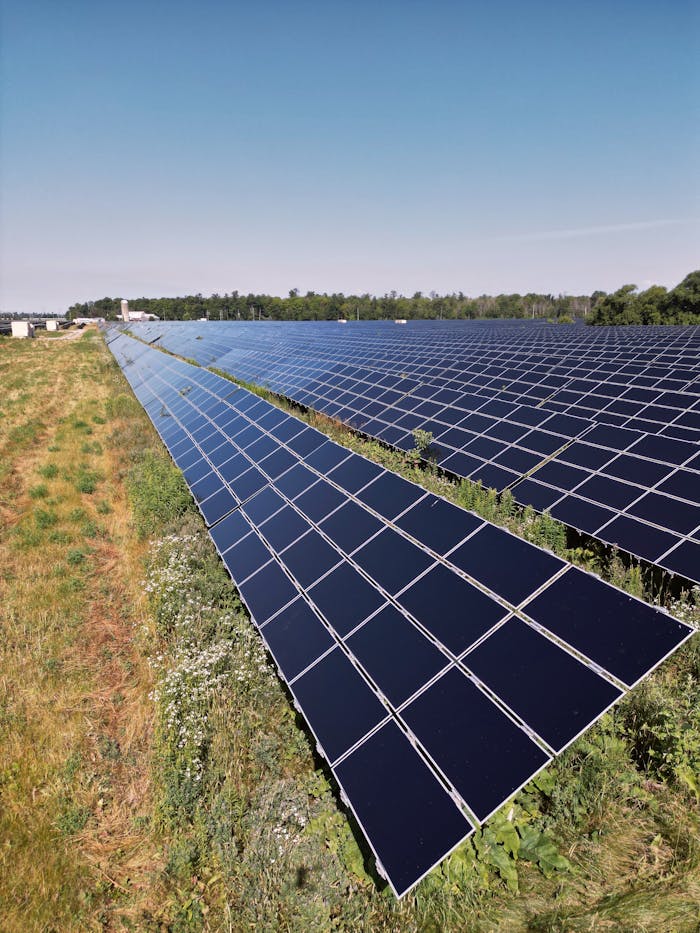 who-we-are Wide view of a solar panel farm under a clear blue sky in Mississippi Mills, ON, promoting renewable energy.